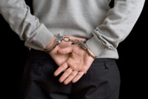 a man with hands cuffed behind his back