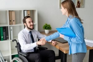 An attorney greeting her client in a wheelchair.